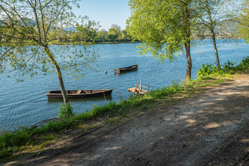 Boats in Lima River. Park bench in river side view in nature landscape, Ponte de Lima, Portugal