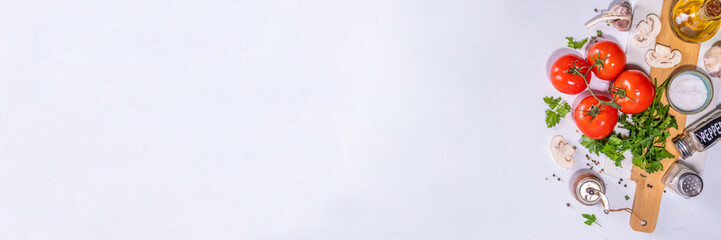 Cooking background with vegetable ingredients. Healthy dinner preparation flat lay, with fresh raw tomatoes, onion, garlic, herbs and greens, olive oil, salt, pepper seasonings, on white background 