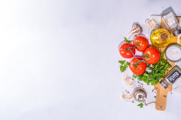 Fototapeta na wymiar Cooking background with vegetable ingredients. Healthy dinner preparation flat lay, with fresh raw tomatoes, onion, garlic, herbs and greens, olive oil, salt, pepper seasonings, on white background 