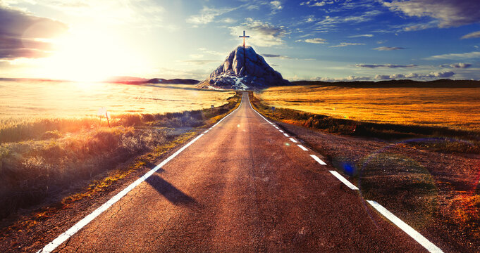 Concepto del viaje hacia el destino y la espiritualidad. Paisaje de campos de cultivo y prados de hierba al atardecer y camino o carretera a la monta&ntilde;a con cruz en la parte superior.