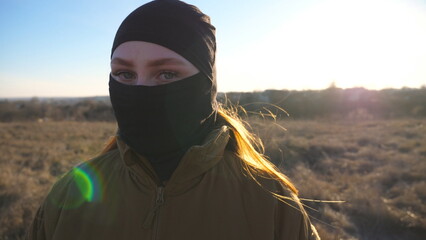 Portrait of female ukrainian soldier looking at camera. Serious sight of woman in military camouflage uniform during war. Victory against russian aggression. Invasion resistance concept. Close up