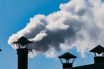 A View of White Smoke Coming out of a Chimney in an Engine Shed on a Sunny Day