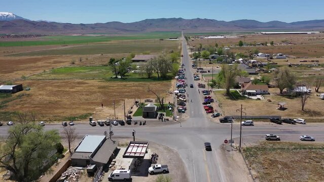 Aerial drone shot of car show on rural desert highway in small western town