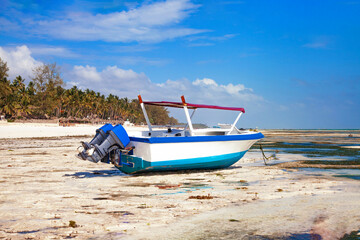 Fototapeta premium Motor boat on the beach during low tide on ocean.