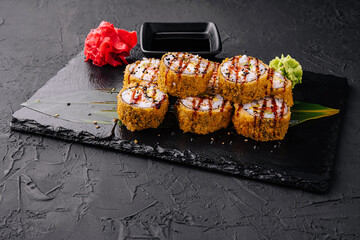 Warm sushi rolls with avocado on black