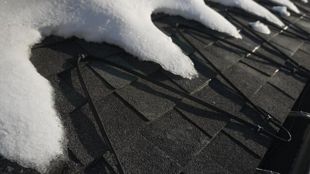 Winter heat cables on the edge of a roof melting snow