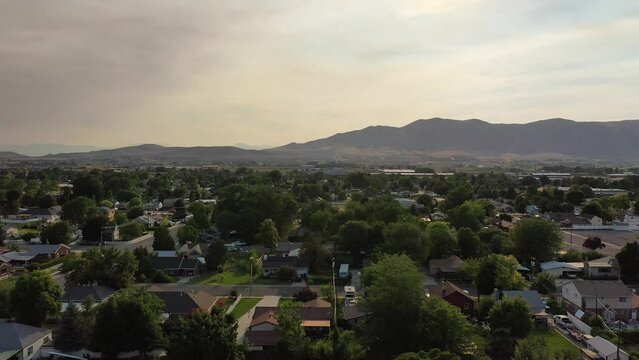 Aerial drone shot of Main Street in rural American town with farms and mountains