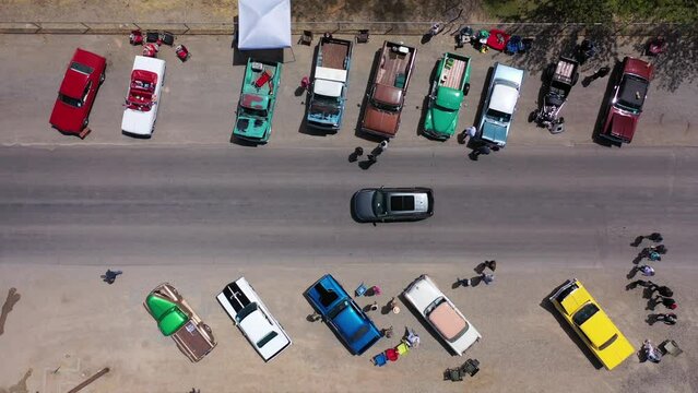 Aerial drone shot of car show on rural desert highway in small western town