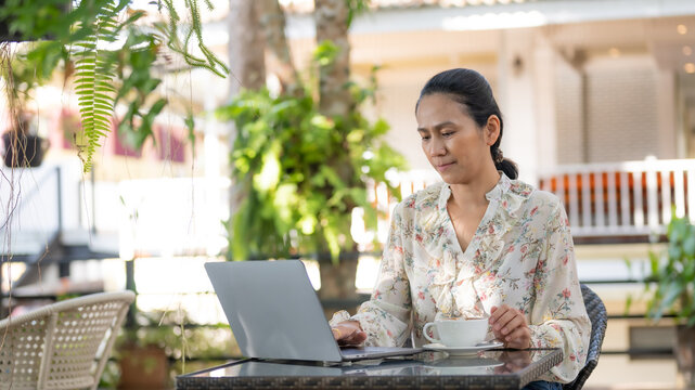 Portrait of Asia businesswomen using laptop working from home