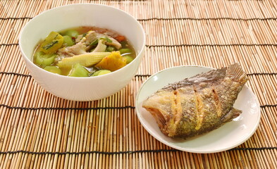 boiled spicy mixed vegetable curry soup on bowl with deep fried snake skin catfish or gourami on dish