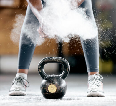 Fitness, chalk or legs by a kettlebell for training, workout or exercise with dust or powder for hand grip. Body builder, mindset or healthy athlete with a heavy weight, motivation or focus at gym
