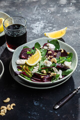 Salad with beets and goat cheese on a dark background