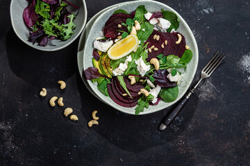 Salad with beets and goat cheese on a dark background