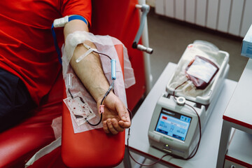 The hand of a man who donates blood. Male donor gives blood in a blood donation center