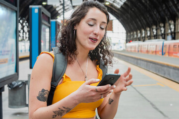 young traveler woman checking the phone happy because they finally transferred money waiting for...