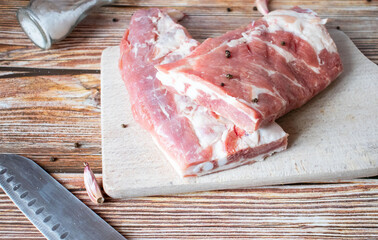 Raw pork ribs with rosemary and black pepper. on a wooden background