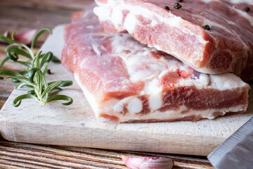Raw pork ribs with rosemary and black pepper. on a wooden background