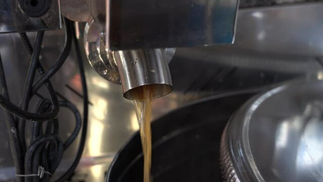 Maple syrup production.  Boiling maple syrup pouring out of boiler into stainless steel container.   Producing maple syrup. Footage.