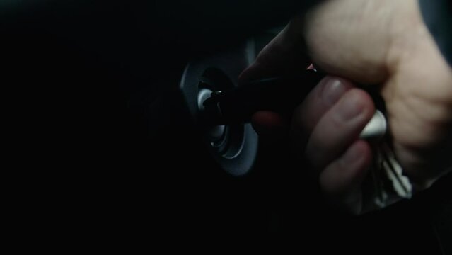 insert the key in the lock of car, man's hand close up, slow motion shot. Turn on the key