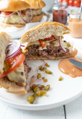 Homemade hamburger cut in half on a plate with burger sauce on kitchen table