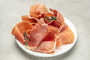 Spanish ham jamon. Slices of prosciutto di parma or jamon serrano on plate. Food recipe background....