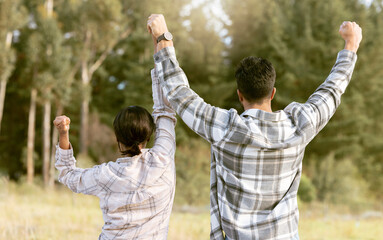 Back, hiking and couple holding hands for success, victory and achievement, fitness and goals in...