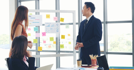 Happy business people meeting present graph chart investment, business data in meeting room. Group of business people meeting in conference room. Asian businessman speech, present teamwork partnership