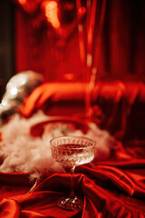 Coupe glass of champagne at red glamour background on valentines day
