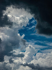 Obraz premium Springtime cloudscape with dark, threatening cloud at top curling downward in foreground, southwest Florida. For concepts of instability and change, uncertainty, uncontrollable forces of nature.