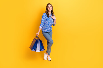 Full body portrait of pretty lady hold boutique packages empty space proposition isolated on yellow color background