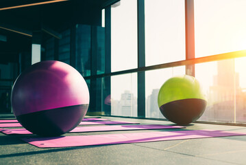 a fitness center and a healthy concept Yoga ball and exercise mat on a wooden floor with a sky-blue...