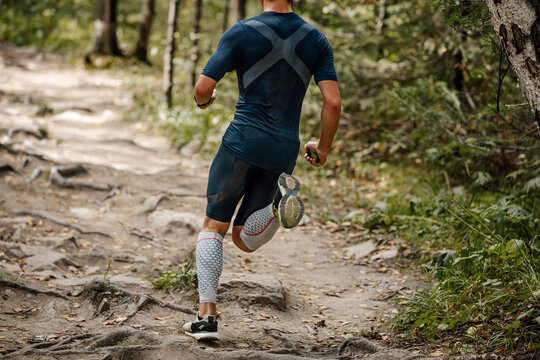 back athlete runner runs in the forest trail