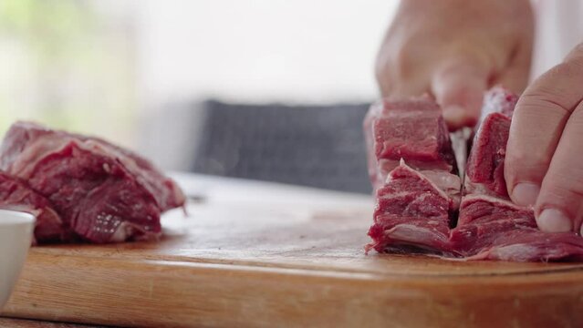Cook at Traditional Churrasco Brazilian Barbecue. Preparing and cutting Ancho meat. Home Grill from Brazil
