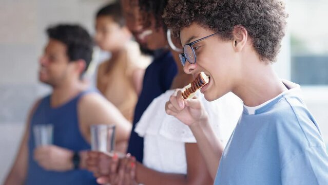 Happy family eating in a traditional brazilian barbecue. Kid eating queijo coalho. People of different ages spending time together at barbecue.
