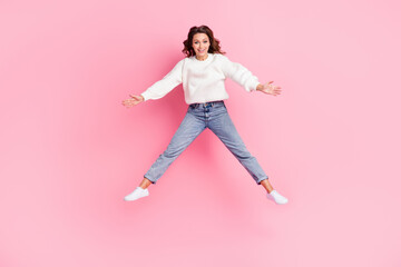 Fototapeta na wymiar Full length photo of adorable excited lady wear white sweater jumping high smiling isolated pink color background