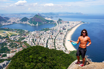 beautiful panoramic aerial view of Rio de Janeiro and a young male tourist from Two Brothers mountain	