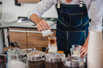 Male barista making coffee, frothed milk, decorated with great coffee pattern service beyond expectation Serve customers in world famous coffee shops