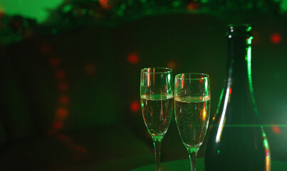 Bottle of champagne and two glasses in night club.
