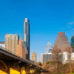 Golden light under the Congress Avenue Bridge at sunrise in Austin downtown, Texas, over the Lady Bird Lake of Colorado River, beautiful modern cityscape and skyline