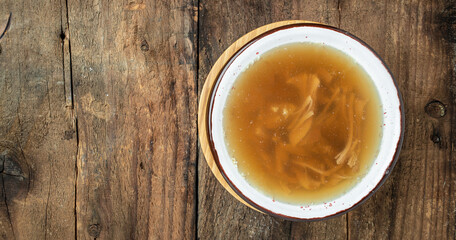 Broth in Bowl with meat pork knuckle on a wooden background, Long banner format. top view