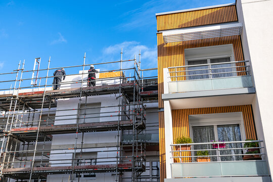 R&eacute;habilitation thermique de logements collectifs. R&eacute;fection de facades avec pose d'un  isolant et de bardage. Situation avant/apr&egrave;s