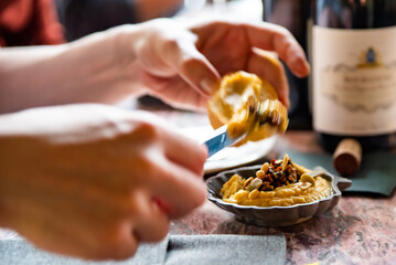 Hand spreading hummus on toast