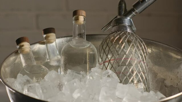 Close-up jin bottles in bucket. Expensive luxurious alcoholic beverage indoors closeup. Alcohol concept