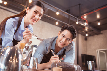 Before competing in the championship level coffee brewing competition, both of the baristas practice their coffee latte makeup techniques to become proficient.