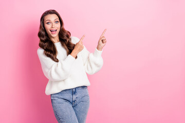 Photo of astonished pretty lady toothy smile direct fingers empty space proposition isolated on pink color background