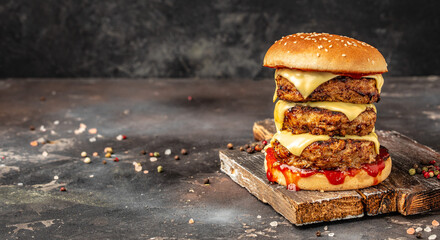 triple patty burger on dark background. fast food and junk food. Long banner format