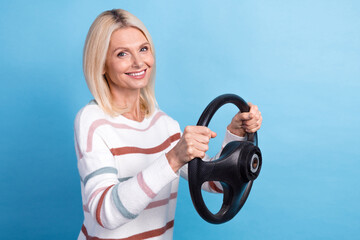 Photo of sweet shiny lady wear striped pullover smiling driving car empty space isolated blue color background