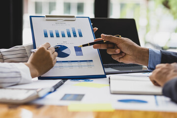 Business finance consultants discuss analysis of marketing reports to assess the profitability of the business.