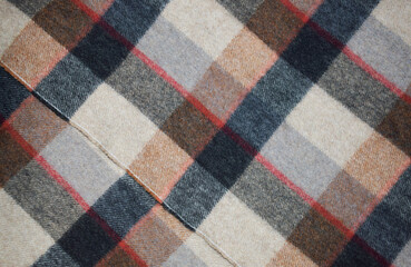 Background of woolen checkered fabric close up.