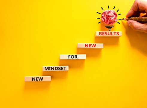 New mindset and results symbol. Concept words New mindset for new results on wooden blocks. Beautiful yellow background. Businessman hand. Business new mindset for results concept. Copy space